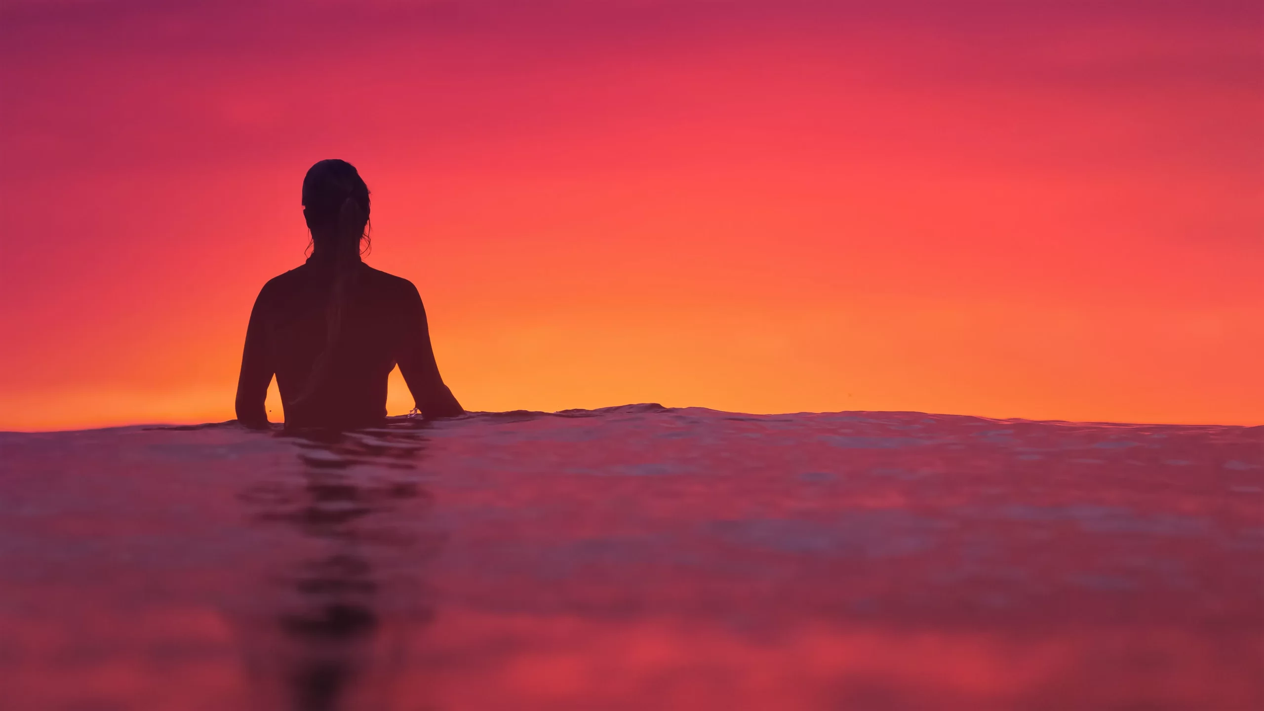 Woman in the sea at sunset